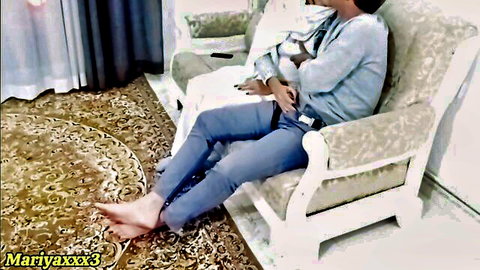 Barefoot woman lounging relaxed on couch in tight blue jeans and sweater