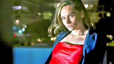 Tori Black in seductive red satin dress and blue blazer, intense gaze