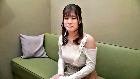 Young Asian JAV amateur in off-shoulder white top and plaid skirt, pouting expression