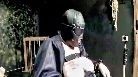 BDSM slave cow in latex hood enduring rubber band torture