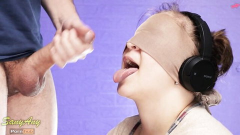 Blindfolded teen with headphones sticks tongue out for cumshot on mouth from man's hard cock