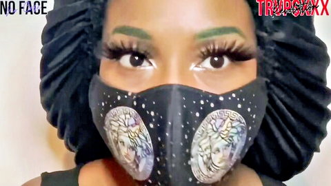 Ebony beauty in satin bonnet and Versace mask, sultry green-eyed gaze