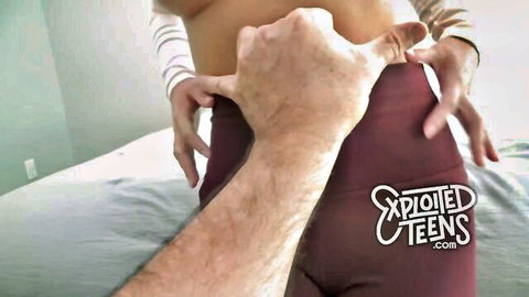 Man's hand pulls aside maroon leggings exposing shaved teen pussy closeup