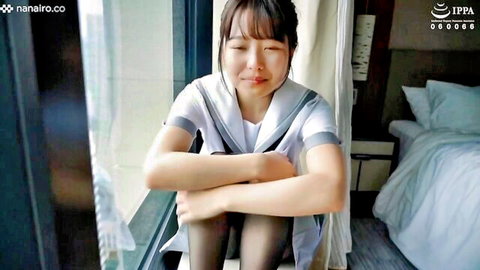 Sensual Asian teen in sailor uniform sitting thoughtfully by window, small tits amateur