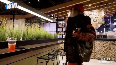 Renata Fox in black coat and red hat, teasing walk in cafe scene