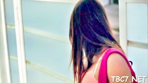 Enticing brunette in pink tank top glancing back seductively