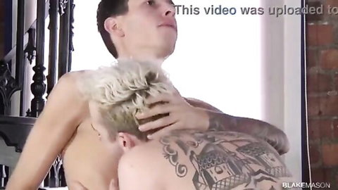 Two shirtless gay friends embracing intimately from behind