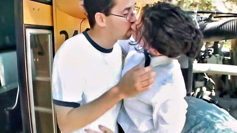 Passionate kiss between glasses guy and curly-haired woman outside yellow school bus