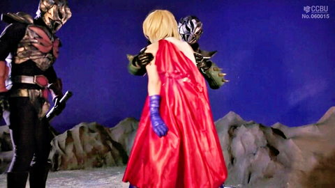 Blonde superheroine in red cape grabbed from behind by two masked armored hunks