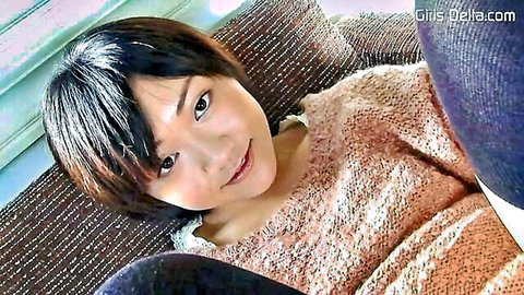 Cute smiling Asian brunette with short hair in fuzzy sweater POV tease on couch