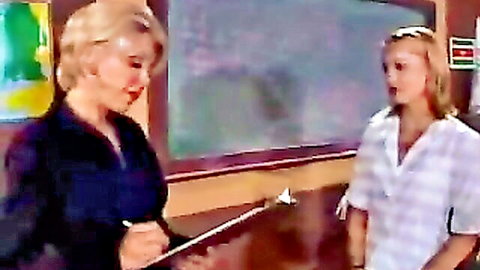 Blonde older teacher and young student in sapphic classroom tease