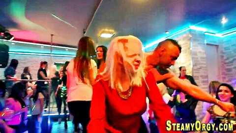 Blonde woman danced with by man at CFNM teen party, vibrant club vibe