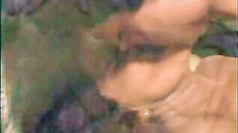 Blurry close-up of mature woman's neck and upper chest with pearl necklace in green tint