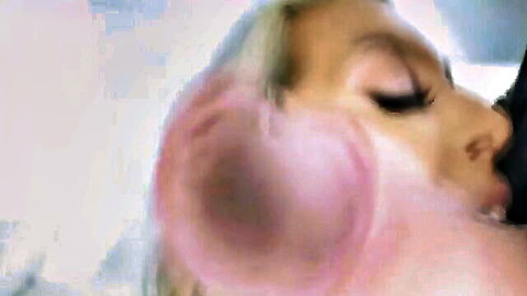 Blonde woman in pink earmuffs passionately kissing man in Dionysus Approved video