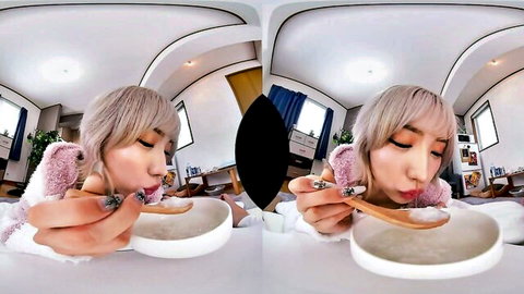 Blonde Asian babe in pink fluffy outfit puckering lips seductively eating from spoon in POV kitchen