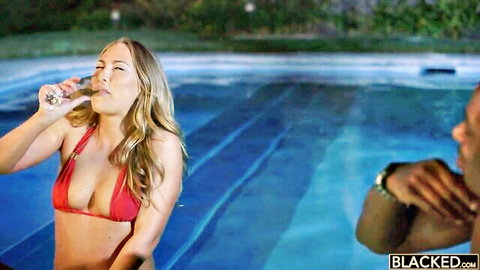 Carter Cruise in red string bikini sips drink by pool with black man nearby