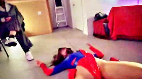 Brunette Supergirl cosplay babe with big tits lies spread-legged on floor under suited man