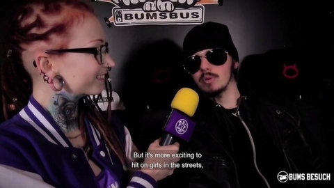 Vanda Angel redhead with tattoos in fetish interview, smiling with mic