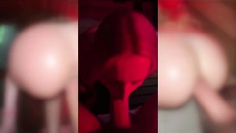 Blurry red-lit closeup of busty woman's face and huge pale tits exposed