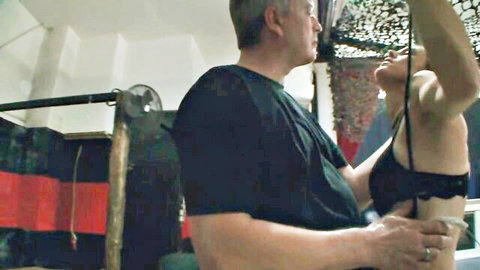 Man holding slim woman in black lingerie from behind in intimate embrace