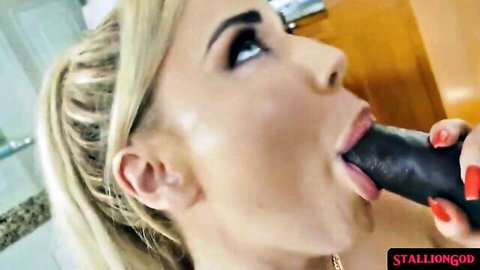 Blonde cougar seductively sucks massive black dildo in interracial tease