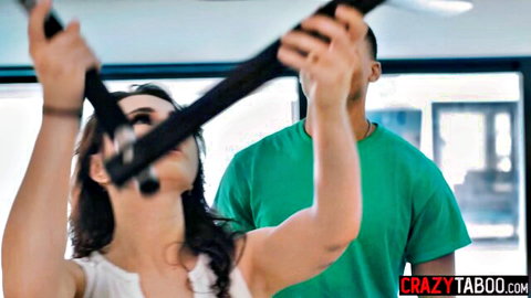 Skinny brunette teen grips gym pull-up bars as black guy presses close from behind in interracial tease.