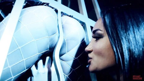 Brunette beauty presses lips to fishnet-clad bubble butt protruding through cage bars