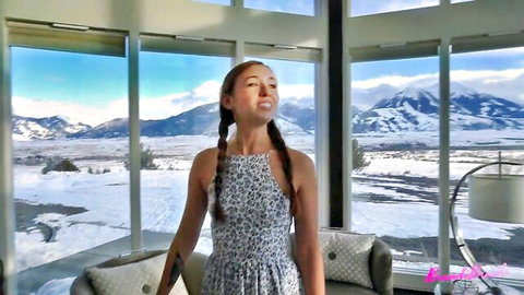 Redhead babe with pigtails in leopard dress smiling in luxury room with snowy mountains