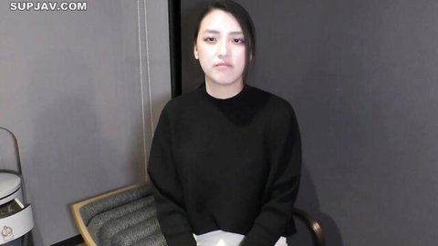 Young Asian woman in black sweater, serious expression, first sex shoot JAV thumbnail