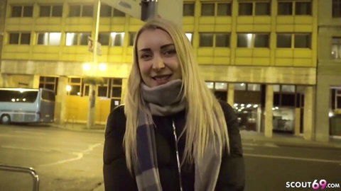 Blonde teen Amaris smiles in street casting, wearing scarf and jacket outdoors