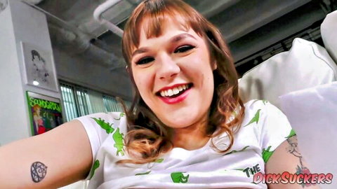 Rebecca Vanguard smiling in dinosaur t-shirt, tattooed arm visible