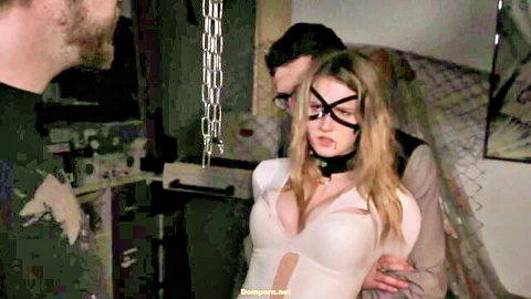 Blonde in BDSM bondage, blindfolded with chains and collar, dominated by two men