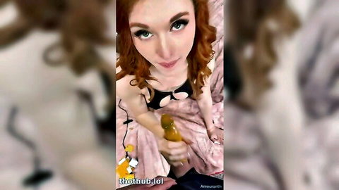 Redhead in black lingerie fucks shaved pussy with thick yellow dildo closeup