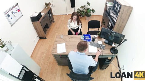 Brunette office babe in tight blouse sits across from colleague at desk flirting seductively