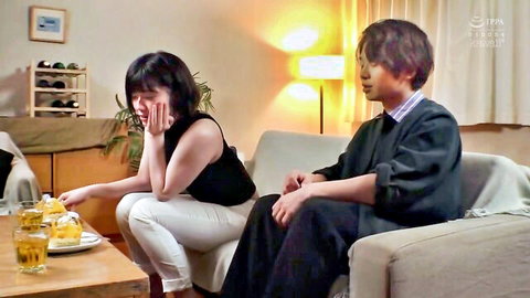 Japanese couple in emotional living room moment, woman in tank top looking distressed