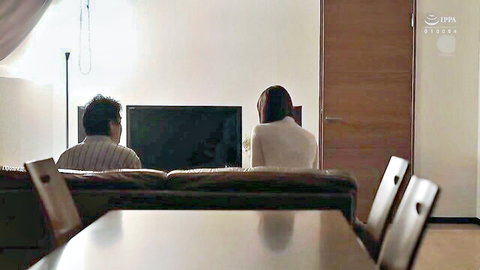Japanese couple intimately watching TV at home, wife in white top