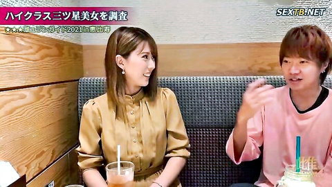 Smiling Japanese woman in blouse chats with man over drinks and cake