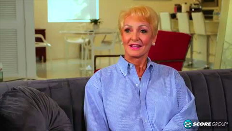 Seka Black mature blonde MILF smiling in blue shirt interview