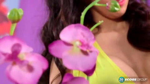 Sexy Latina with massive cleavage in green top, pink orchids, kissy lips