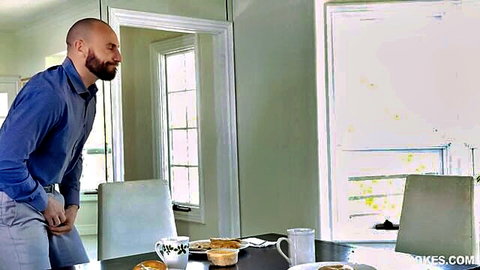 Bearded bald DILF in blue shirt grabs crotch bulge by kitchen breakfast table