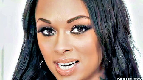 Seductive ebony beauty with glossy lips smiling teasingly close-up