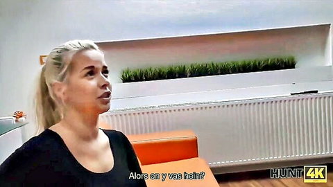 Blonde European woman in black top sitting on couch in Hunt4K cheating cash scene