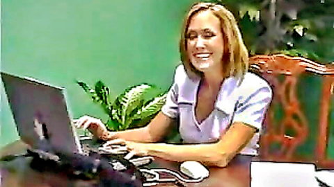 Brandi Love smiling in white blouse at desk typing on laptop
