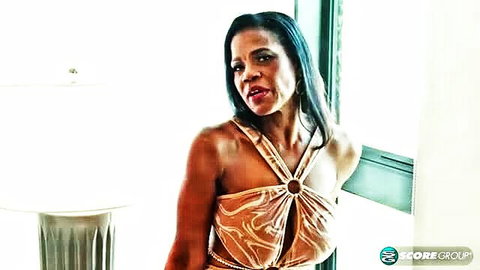 Raven Swallowz in shiny gold revealing dress, seductive pose