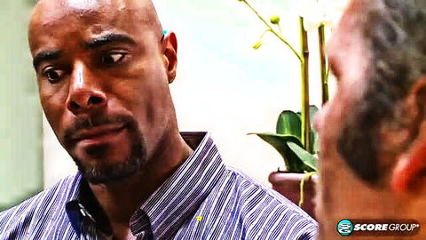 Black employee in striped shirt talks benefits with gray-haired boss