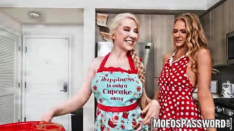 Two busty blondes in sexy aprons and dress baking in kitchen