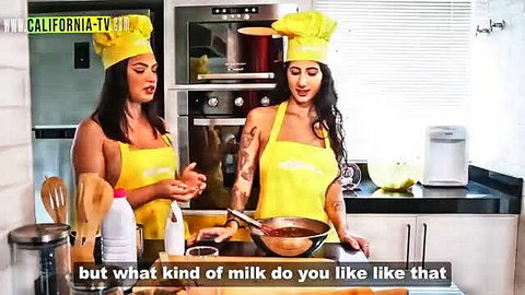 Two busty brunettes in yellow aprons cooking playfully on TV show