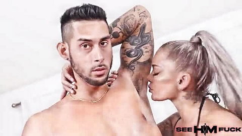 Tattooed muscular hunk kissed by busty blonde in bikini