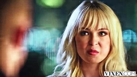 Hot blonde with bangs stares seductively in neon-lit closeup