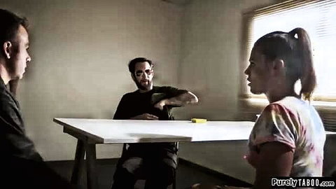 Brunette ponytail woman talks with two men at table in tense scene